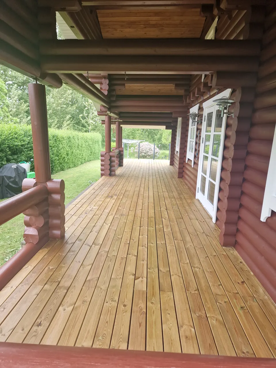 Overdækket træterrasse ved bjælkehus